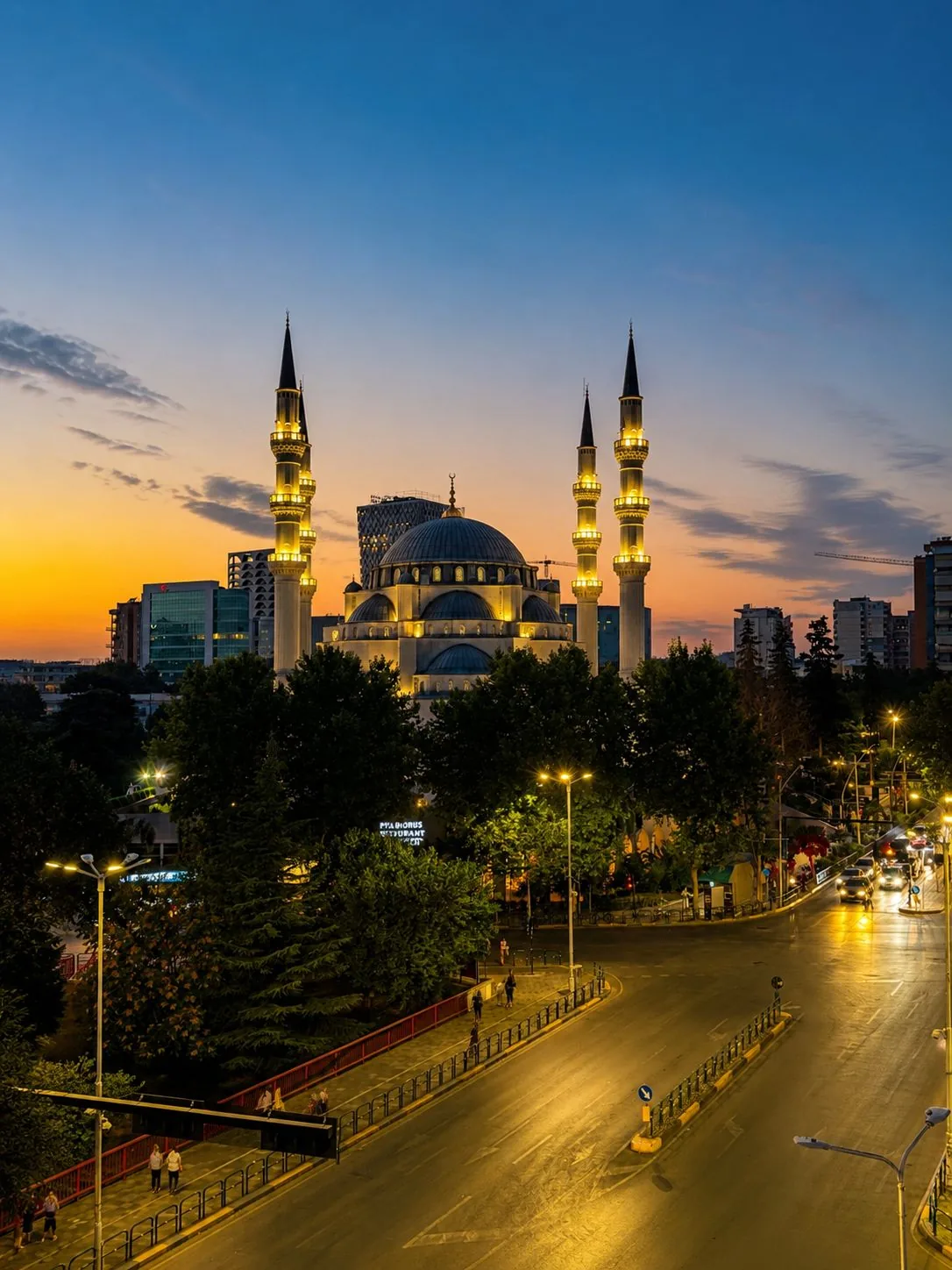 The illuminated Namazgah Grand Mosque in Tirana at dusk seen from the apartment